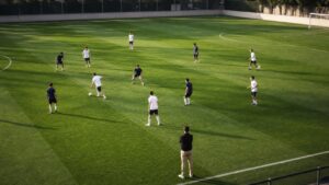 Soccer players in plain kits working through a positional possession drill on a training pitch