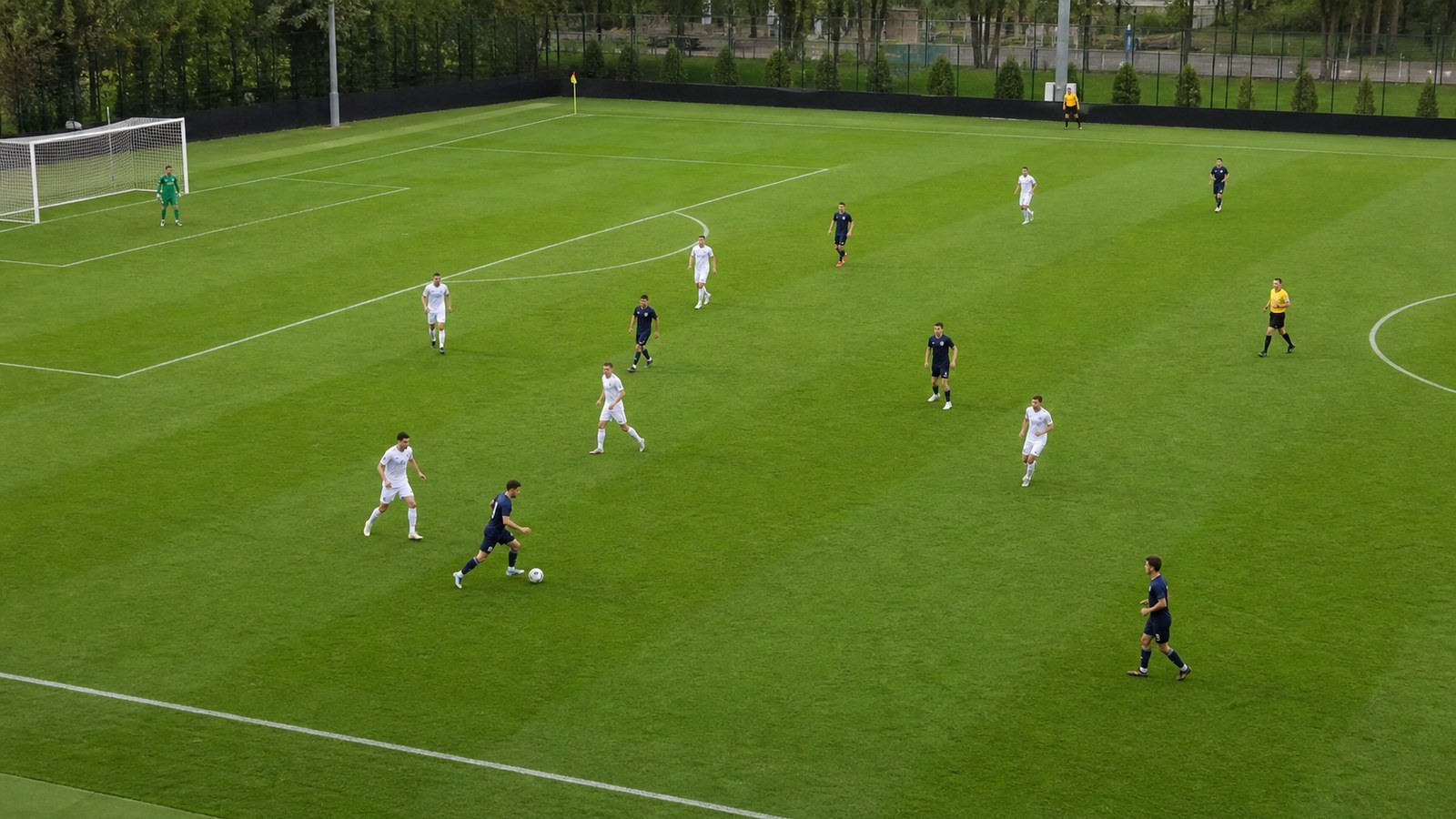 Practice match with players in different soccer positions spread across a grass pitch